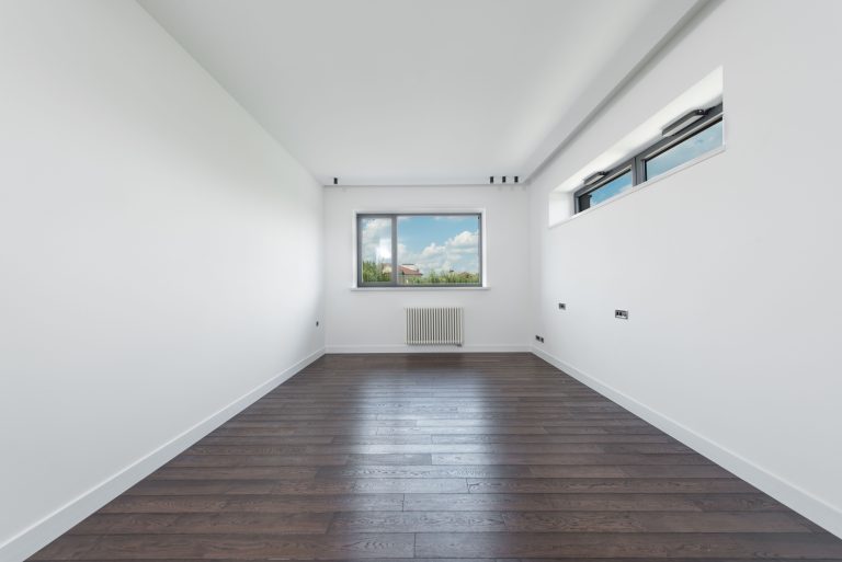 Freshly refinished dark-stained hardwood flooring in an empty Tennessee room