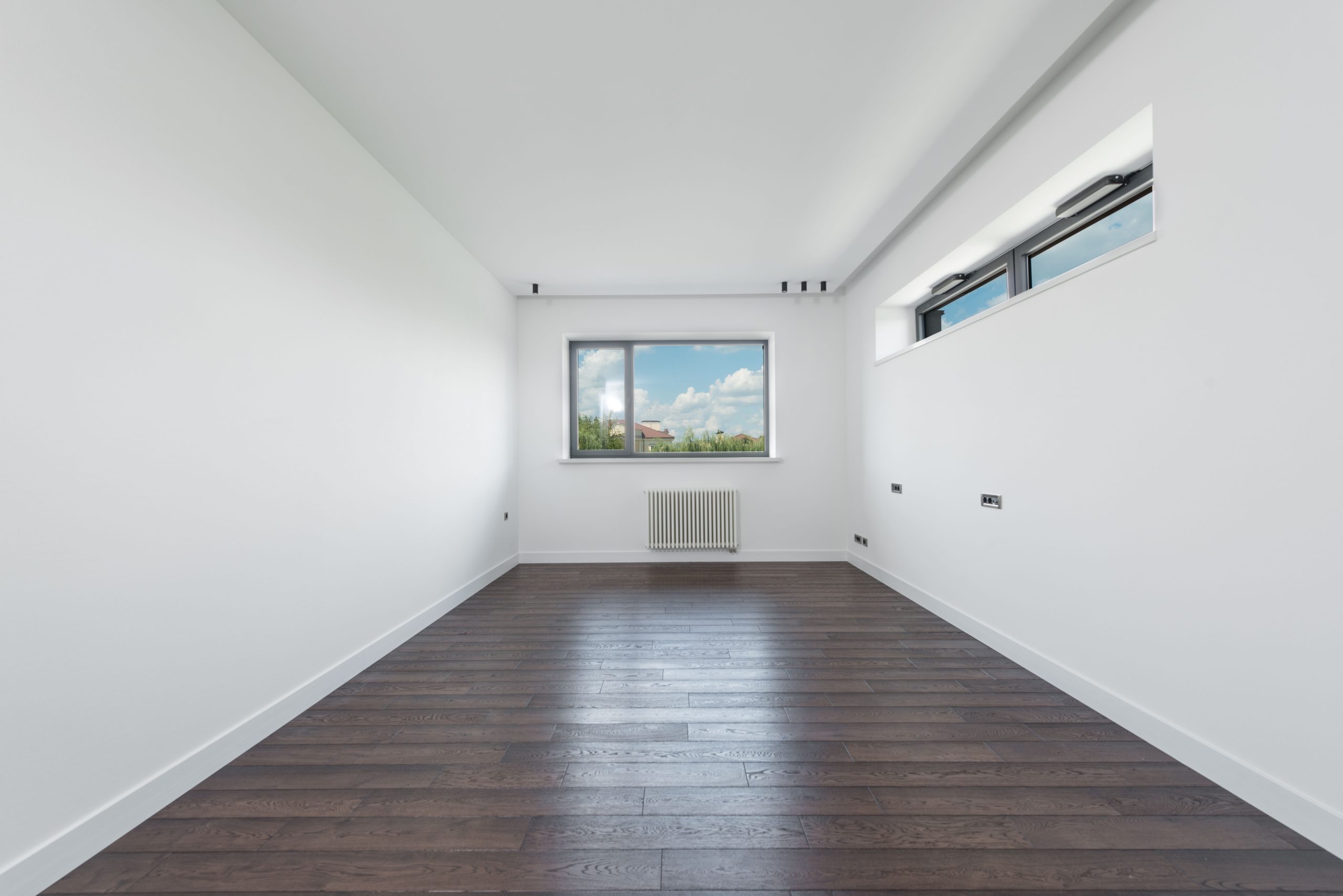 Freshly refinished dark-stained hardwood flooring in an empty Tennessee room
