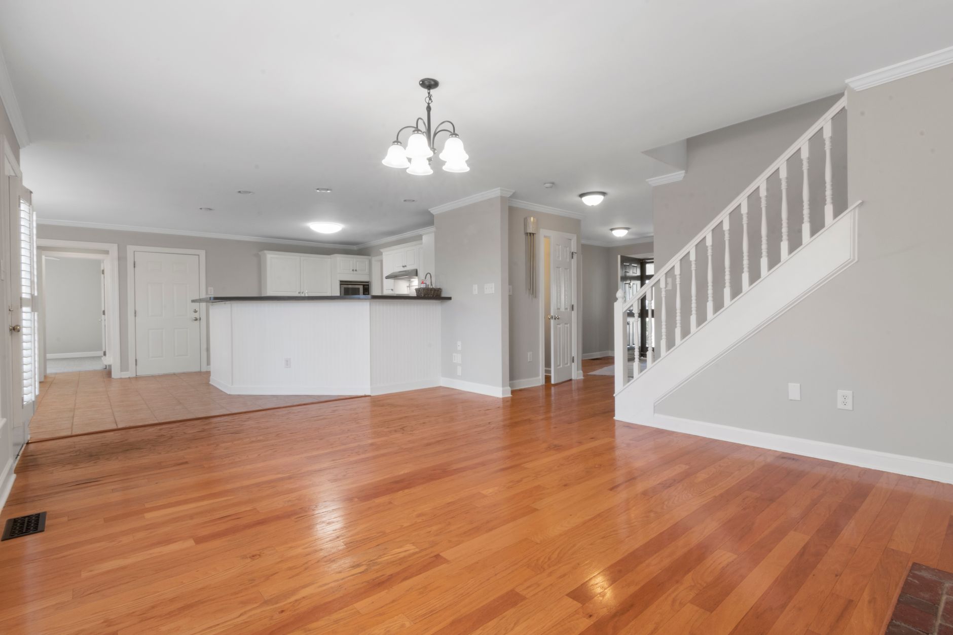 Bright and airy open floor plan with hardwood flooring and white kitchen cabinets